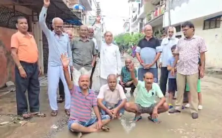 गड्ढों में तब्दील सड़क पर बैठकर प्रशासन के खिलाफ जताया आक्रोश